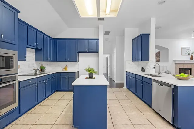 a large kitchen with stainless steel appliances granite countertop a sink counter space cabinets and a stove