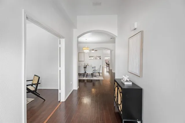 a view of a hallway with wooden floor and a living room