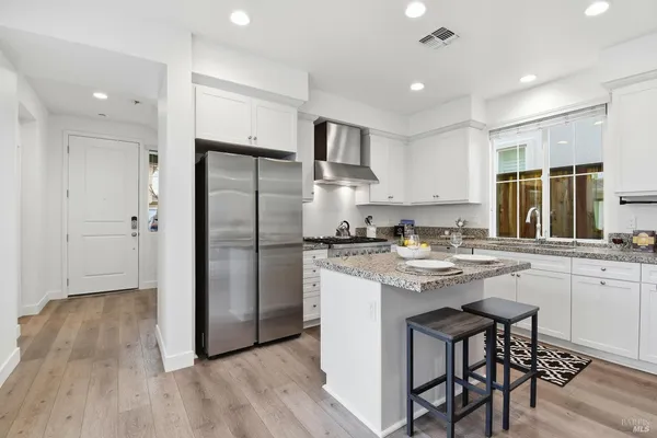 a kitchen with stainless steel appliances granite countertop a sink stove and refrigerator