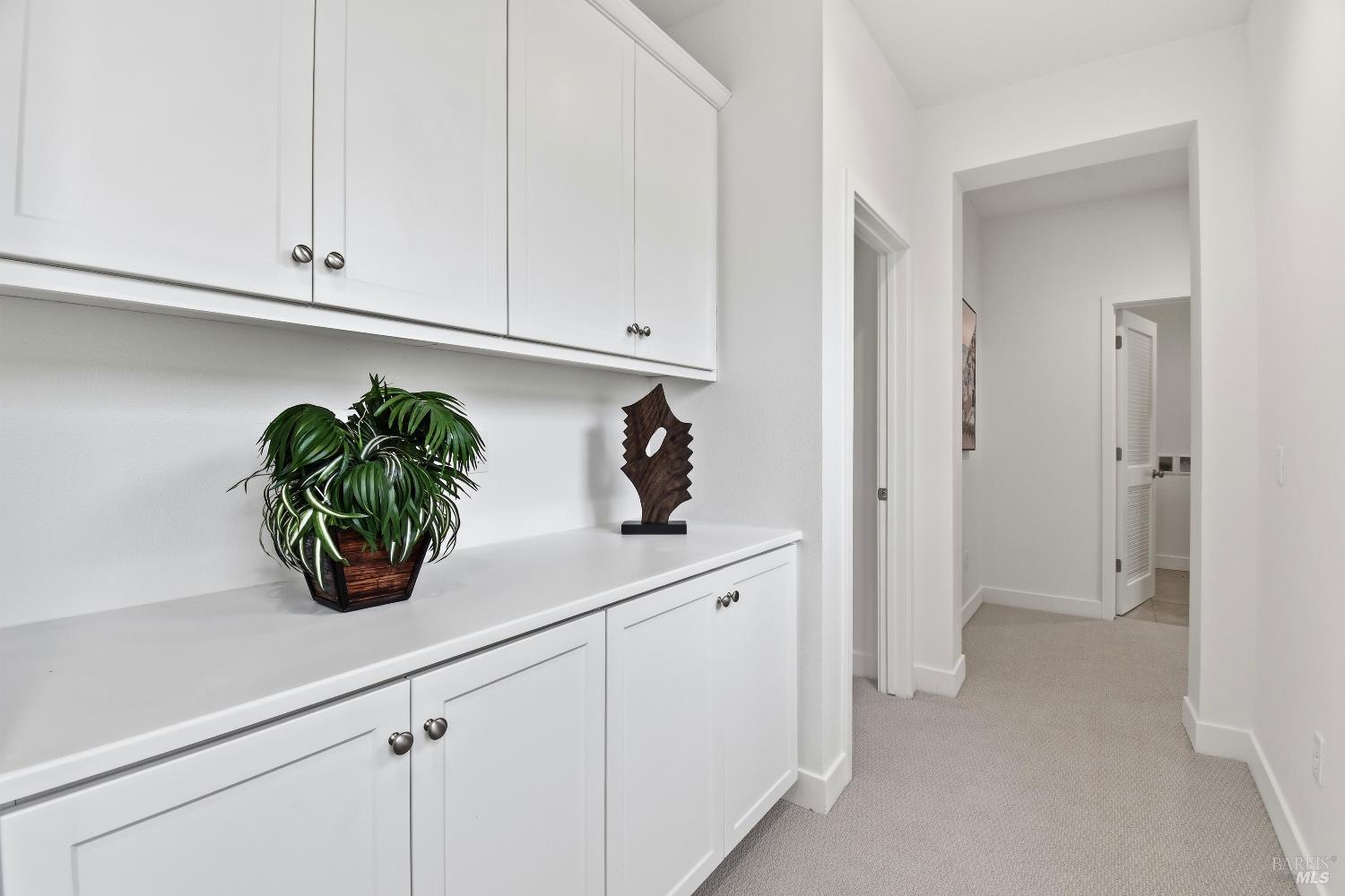1612 Rose Clover Street Santa Rosa, CA 95403 - Photo 21 of 40 a white kitchen with white cabinets and potted plant