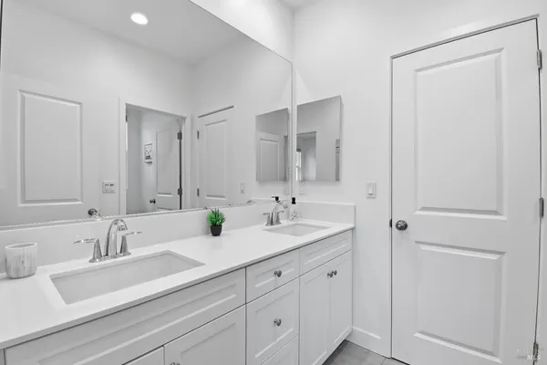 a bathroom with double sink and a mirror