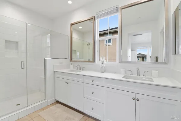a bathroom with a double vanity sink and mirror