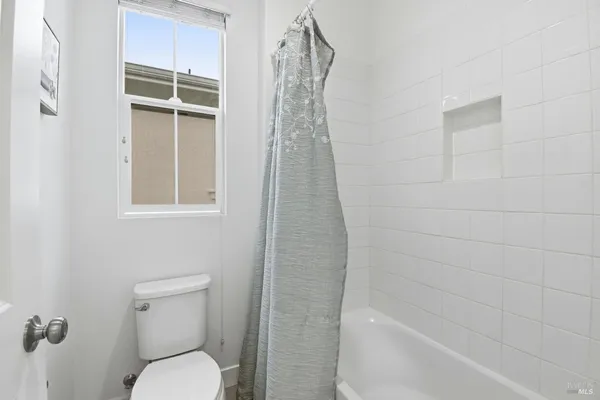 a bathroom with a shower a toilet and a window