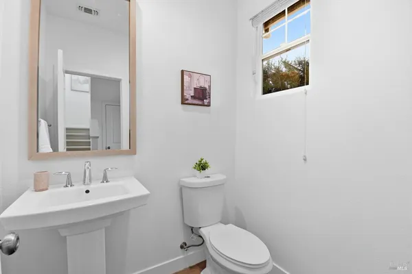 a bathroom with a sink mirror and a toilet