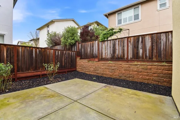 a view of a backyard with a chair and table in the patio
