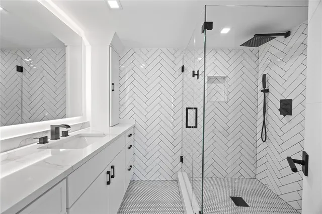 a bathroom with a double vanity sink a mirror and shower