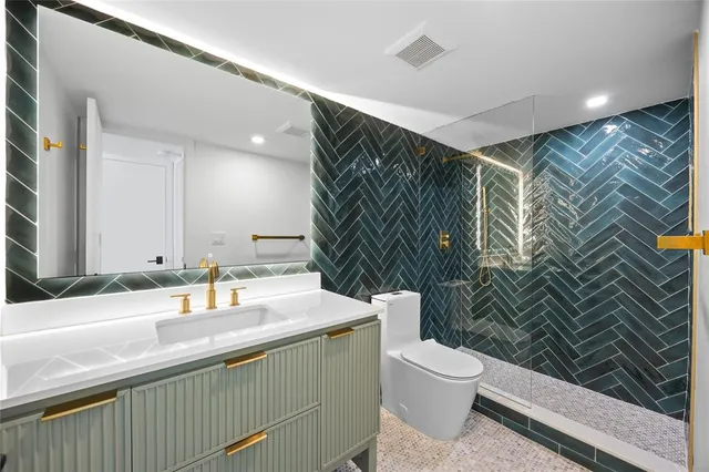 a bathroom with a sink a toilet and shower