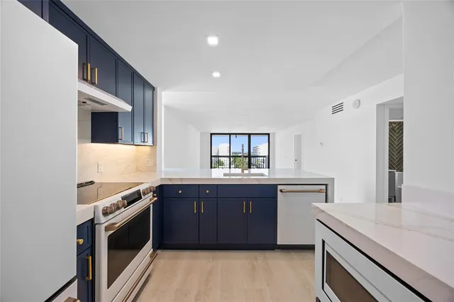 a kitchen with stainless steel appliances granite countertop a stove and a sink