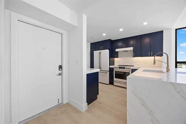 a large kitchen with a stove a refrigerator and a sink