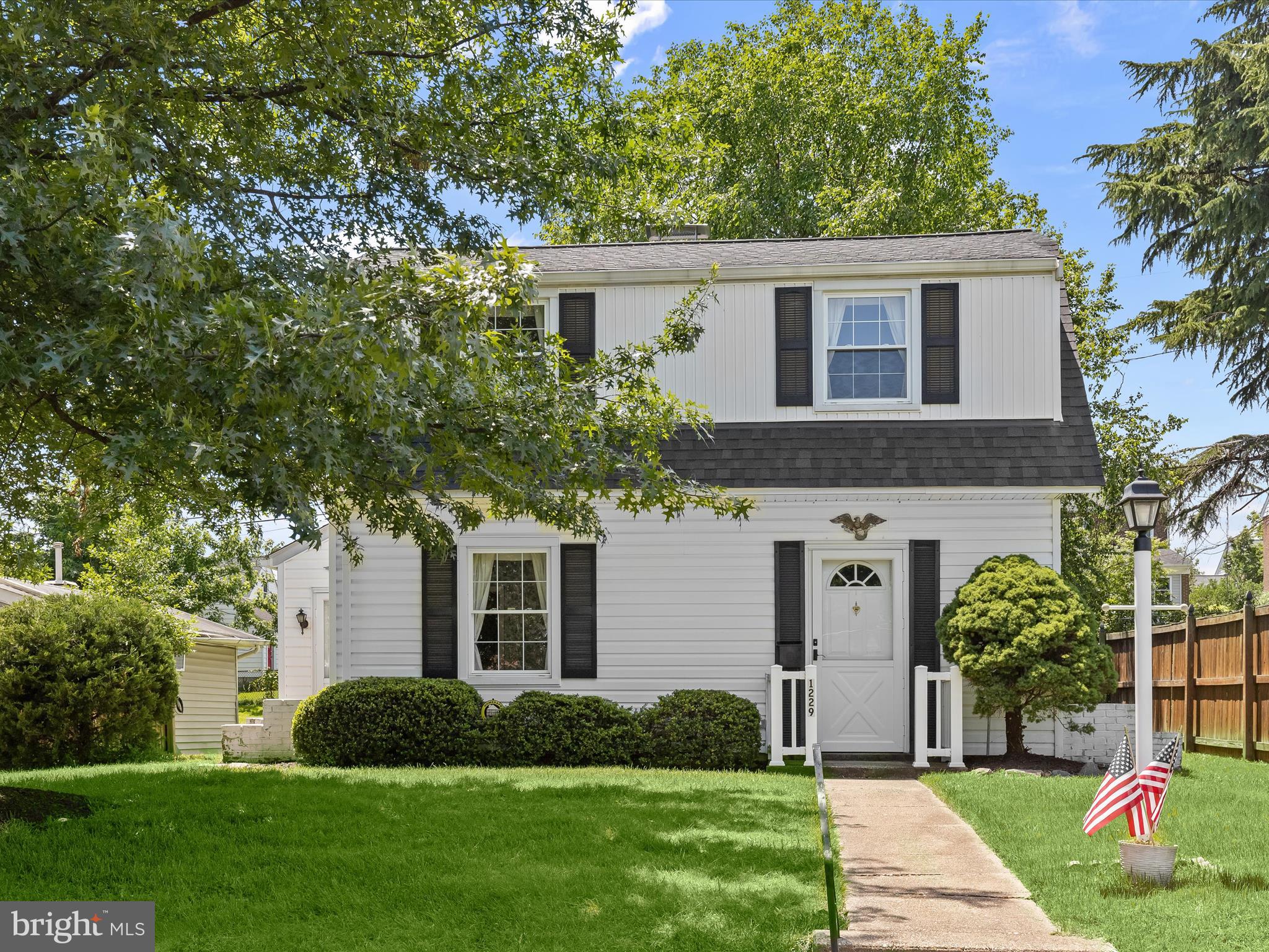 a front view of a house with a yard and trees