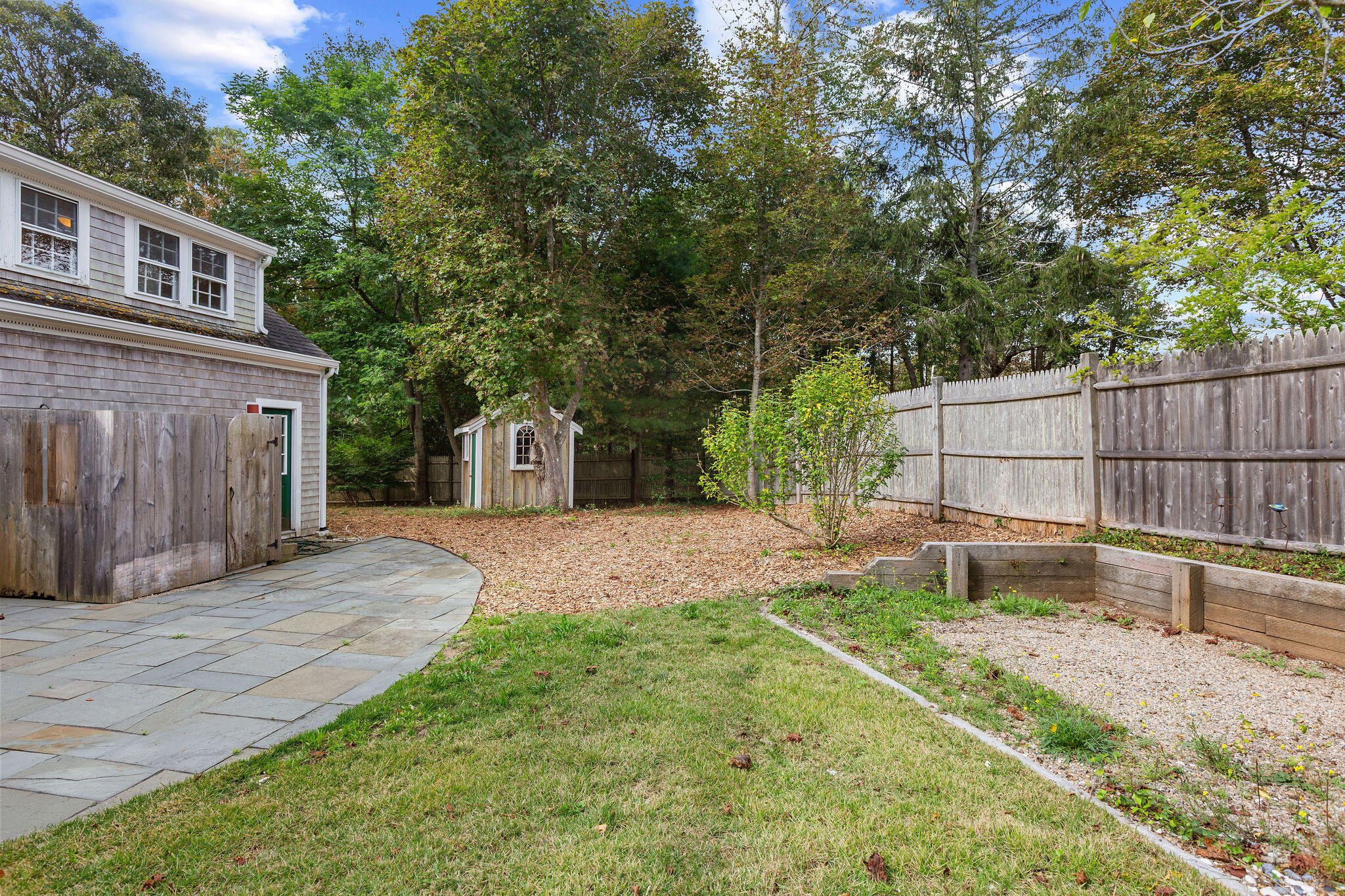 44 Beriah Brooks Road Harwich, MA 02645 - Photo 10 of 43 a backyard of a house with wooden fence and large trees
