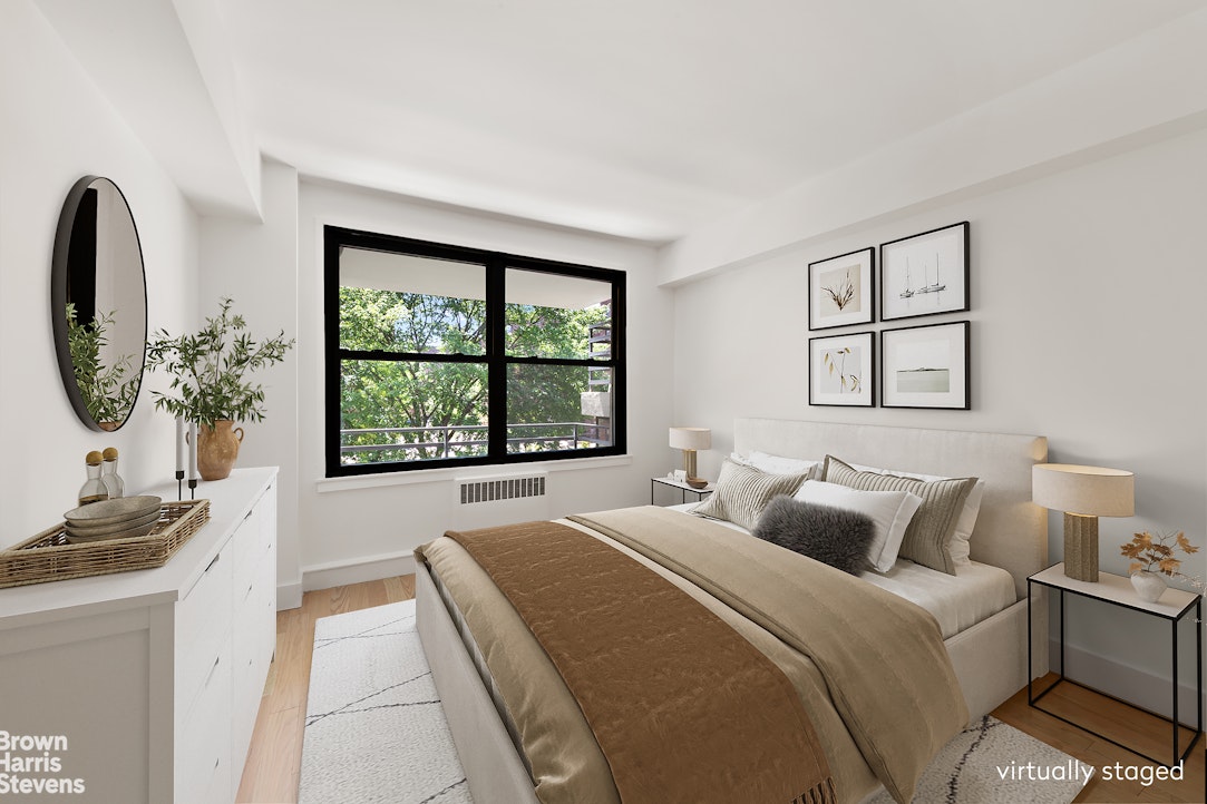 98-41 64th Road, Unit 3G Queens, NY 11374 - Photo 5 of 14 a bedroom with a bed a mirror on dresser and a window