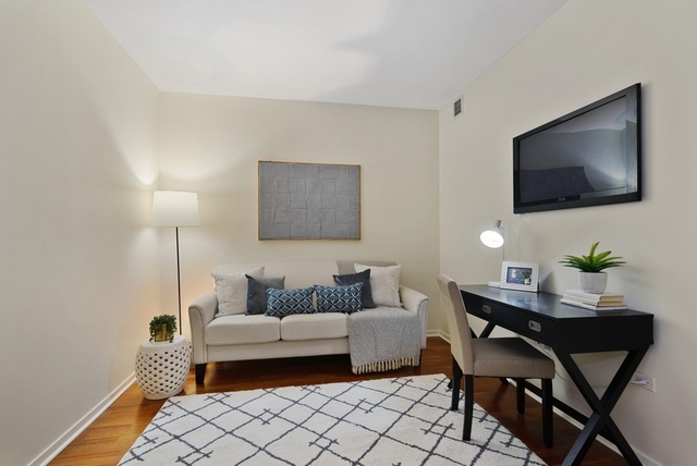 807 Davis Street, Unit 1504 Evanston, IL 60201 - Photo 7 of 14 a living room with furniture and a flat screen tv