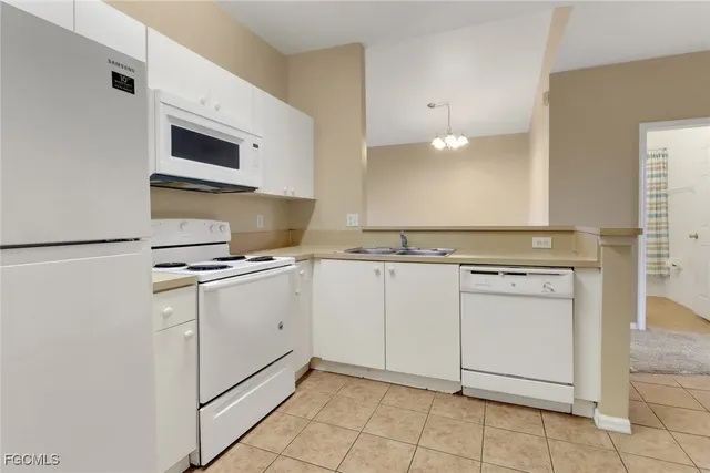 a kitchen with white cabinets appliances and sink
