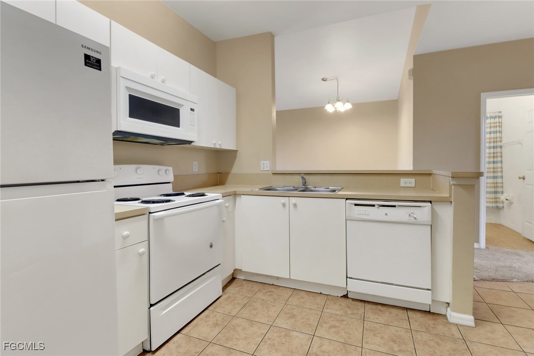 4214 Bellasol Circle, Unit 824 Fort Myers, FL 33916 - Photo 20 of 27 a kitchen with white cabinets appliances and sink