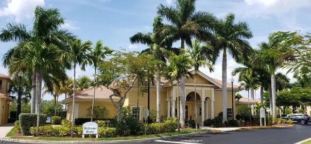 a front view of a house with a tree