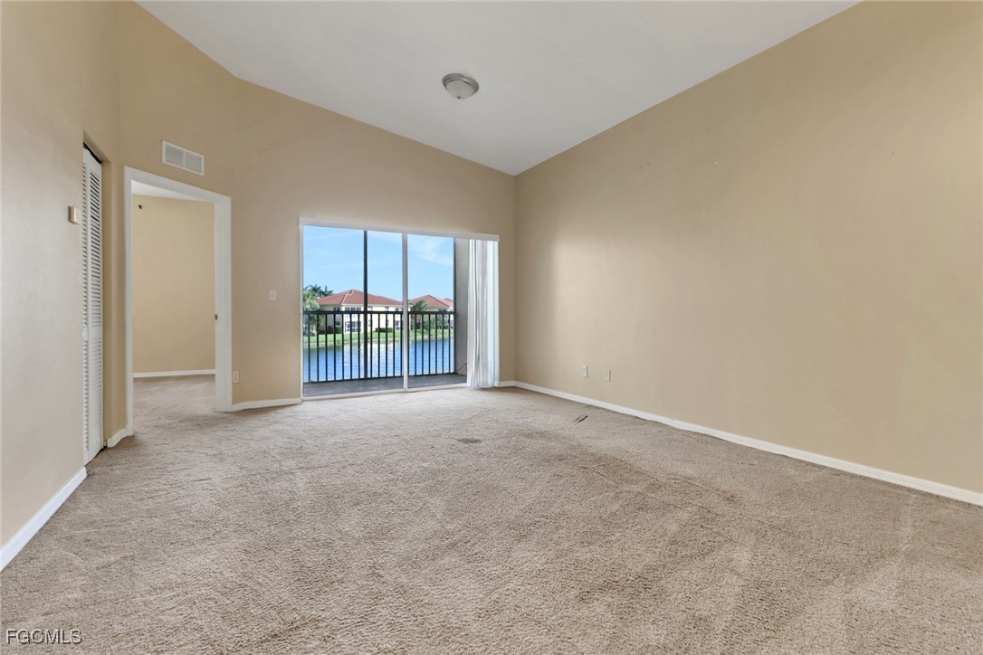 4214 Bellasol Circle, Unit 824 Fort Myers, FL 33916 - Photo 9 of 27 an empty room with a fireplace and painted walls