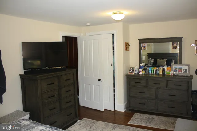 a room with a flat screen tv on dresser and a dresser