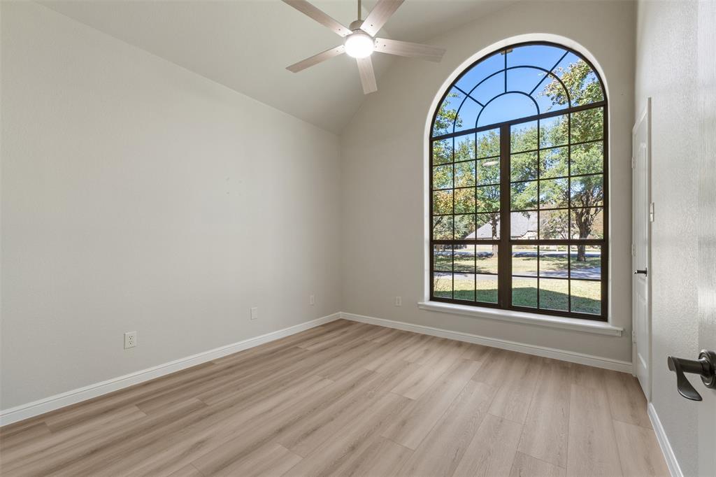 615 West Aurora Vista Trail Aurora, TX 76078 - Photo 24 of 40 an empty room with wooden floor windows and a ceiling fan