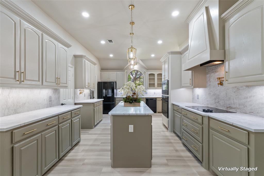 615 West Aurora Vista Trail Aurora, TX 76078 - Photo 9 of 40 a large kitchen with stainless steel appliances kitchen island granite countertop a stove top oven a sink dishwasher a dining table and chairs with wooden floor