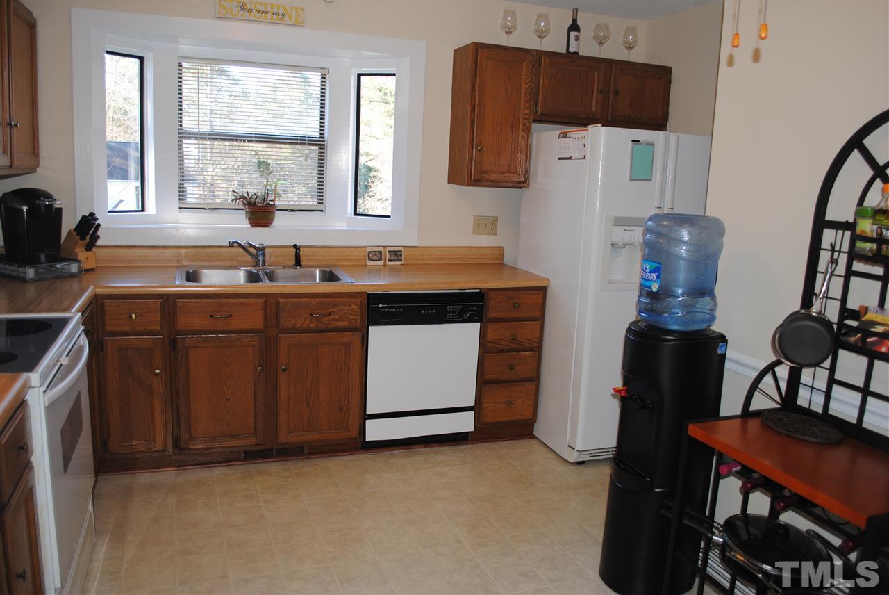 5408 Ridgeloch Place Raleigh, NC 27612 - Photo 13 of 25 a kitchen with stainless steel appliances a stove a refrigerator a sink a counter space and cabinets