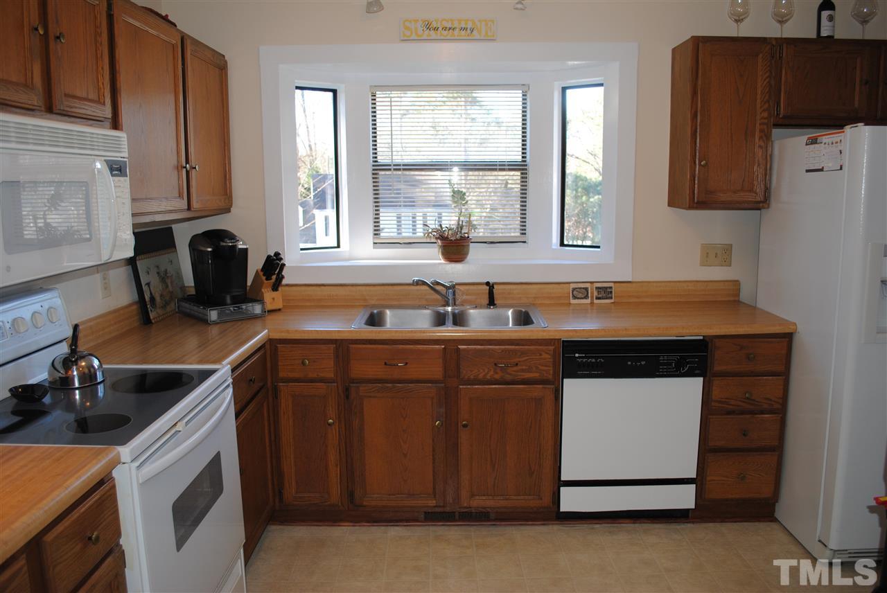 5408 Ridgeloch Place Raleigh, NC 27612 - Photo 14 of 25 a kitchen with granite countertop a sink a stove and refrigerator