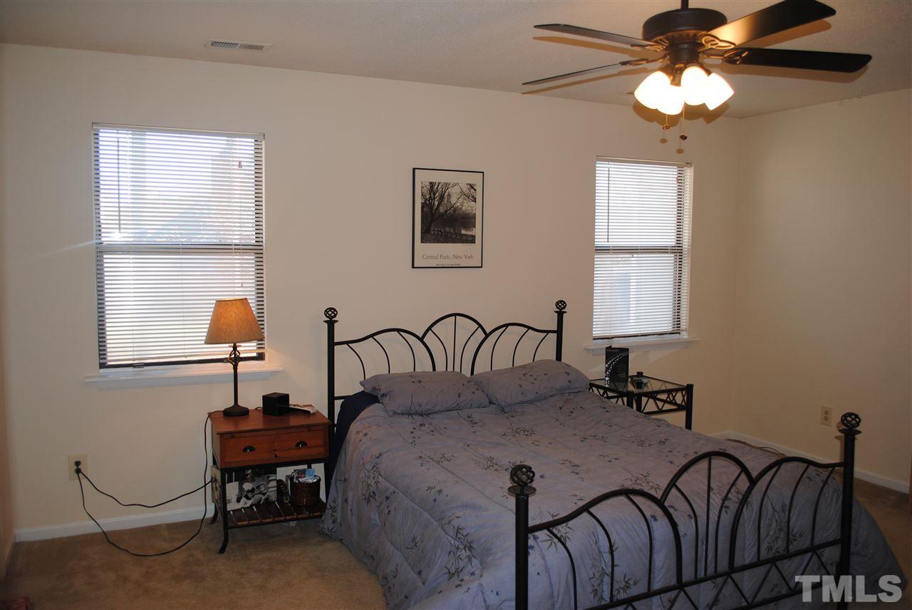 5408 Ridgeloch Place Raleigh, NC 27612 - Photo 17 of 25 a bedroom with a bed and a chandelier