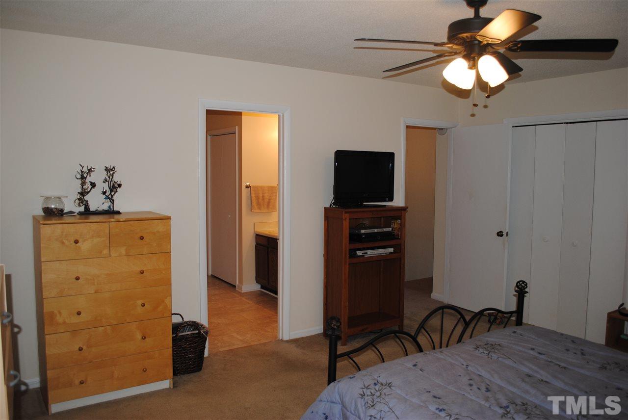 5408 Ridgeloch Place Raleigh, NC 27612 - Photo 18 of 25 a bedroom with a bed and a flat tv screen on dresser
