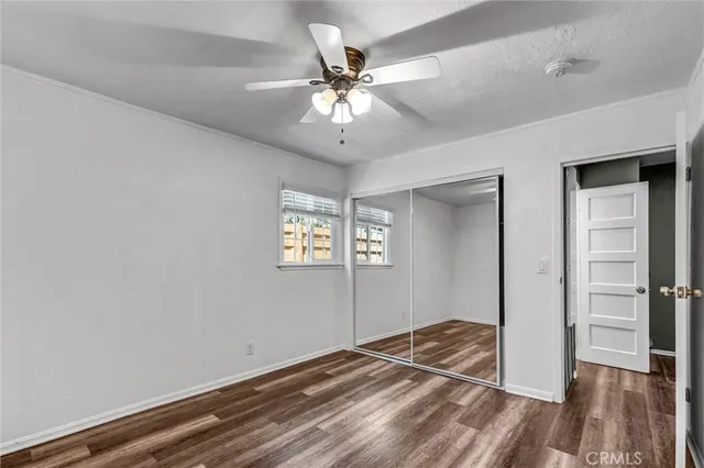 a view of a livingroom with a ceiling fan and wooden floor