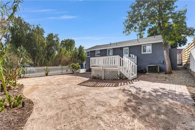 a white house that has a tree in front of it