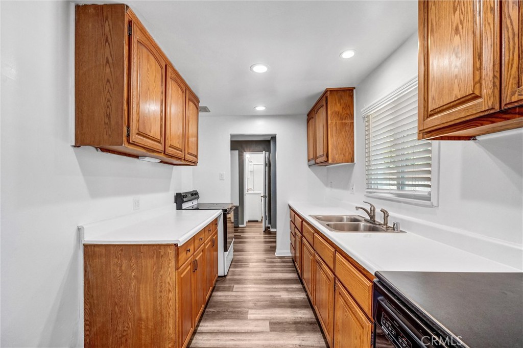 9246 Rowell Avenue Chatsworth, CA 91311 - Photo 10 of 22 a kitchen with stainless steel appliances granite countertop lots of counter space and wooden floors