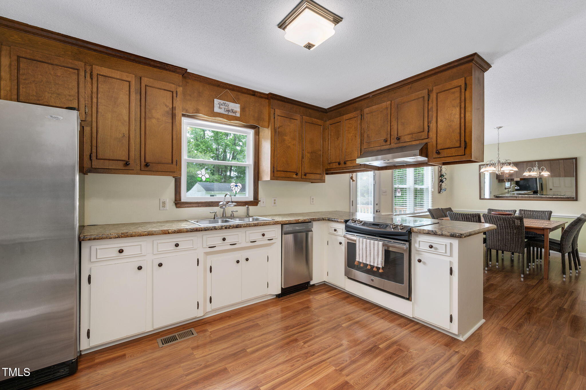 124 Windmere Drive Angier, NC 27501 - Photo 20 of 39 a kitchen with granite countertop wooden floors stainless steel appliances a sink and a window