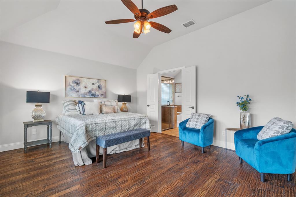 1609 Emerald Tree Place Aubrey, TX 76227 - Photo 13 of 39 a bedroom with a bed and a chandelier