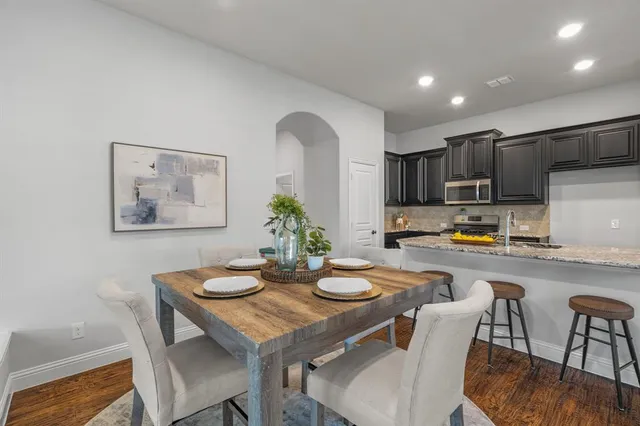 a kitchen with a dining table chairs and refrigerator