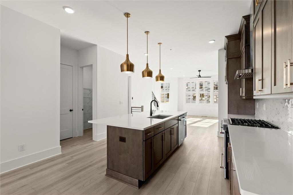 437 Mezzo Lane, Unit 87 Alpharetta, GA 30009 - Photo 15 of 46 a kitchen with stainless steel appliances granite countertop a sink a stove and a wooden floor