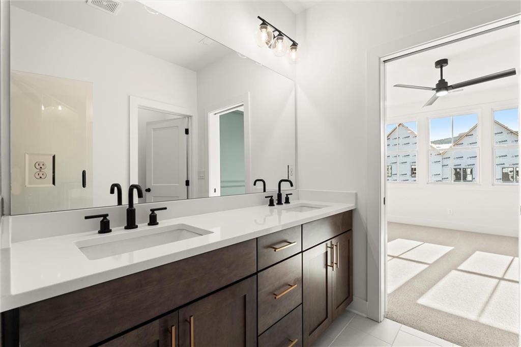 437 Mezzo Lane, Unit 87 Alpharetta, GA 30009 - Photo 27 of 46 a bathroom with a double vanity sink a mirror and shower