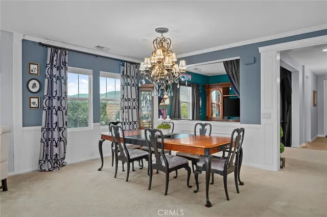 a dining room with furniture a chandelier and a rug