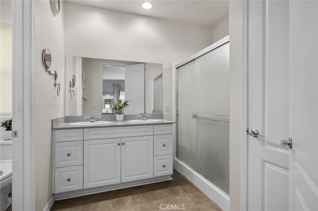 a bathroom with a granite countertop sink a mirror a vanity and a shower