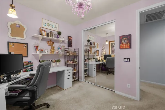 a view of a workspace with furniture and a window