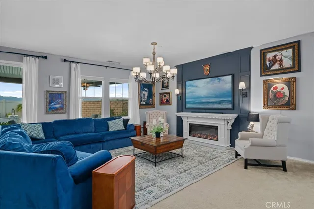 a living room with furniture a fireplace and a chandelier