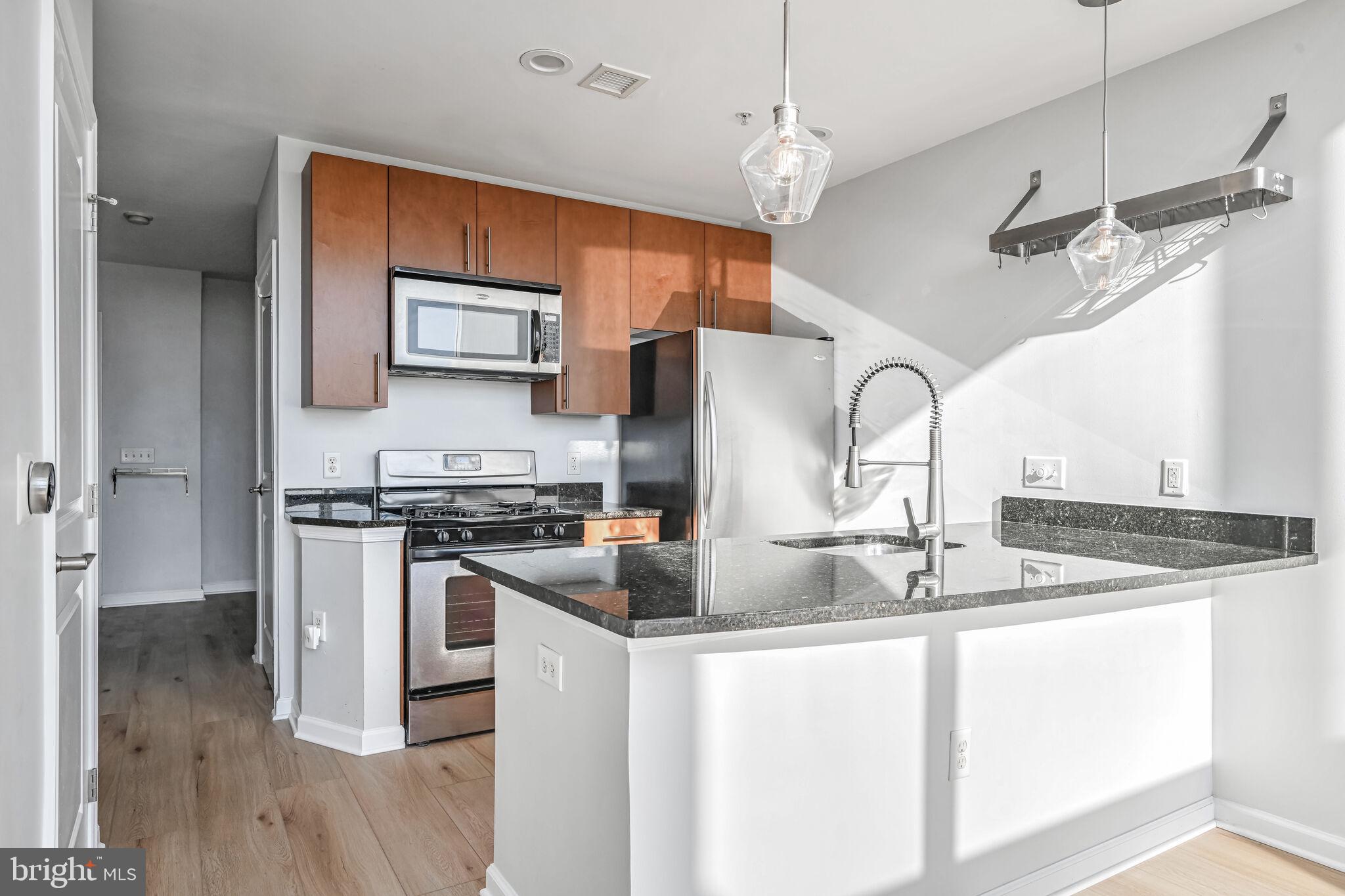 444 West Broad Street, Unit 619 Falls Church, VA 22046 - Photo 6 of 21 a kitchen with stainless steel appliances granite countertop a sink and a refrigerator