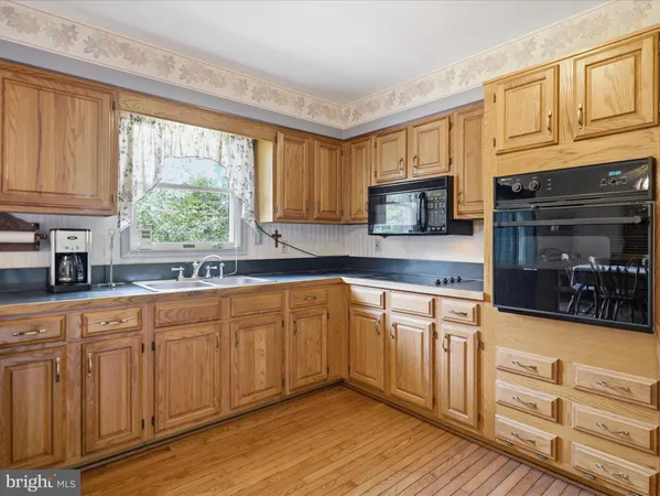 a kitchen with stainless steel appliances granite countertop a stove a sink and a granite counter tops with wooden floors