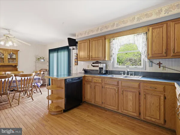 a kitchen with stainless steel appliances granite countertop a stove a sink dishwasher and a refrigerator with wooden cabinets