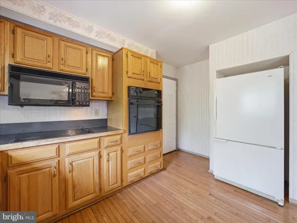 a kitchen with granite countertop wooden cabinets stainless steel appliances and a window