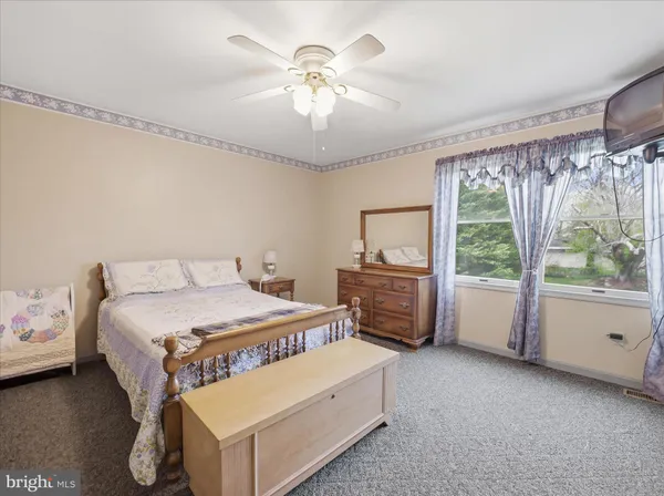 a bedroom with a bed and a chandelier fan