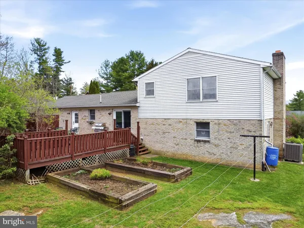 a view of house with backyard and a garden