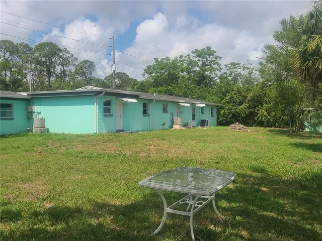 a backyard of a house with table and chairs