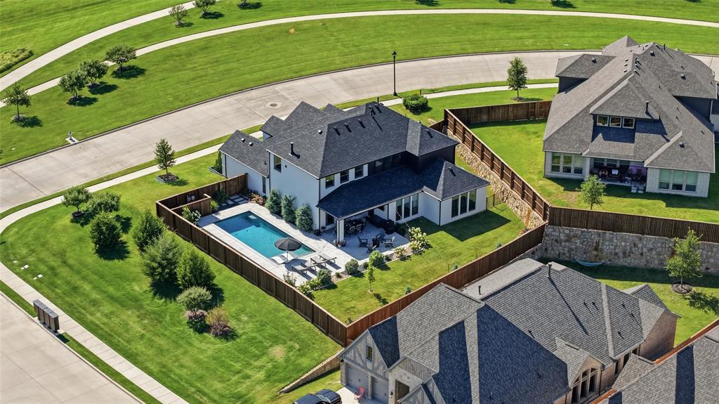 4202 Crown Run Road Midlothian, TX 76065 - Photo 2 of 34 Contemporary residence featuring a private backyard swimming pool, expansive patio, covered outdoor living area, and a dark shingle roof