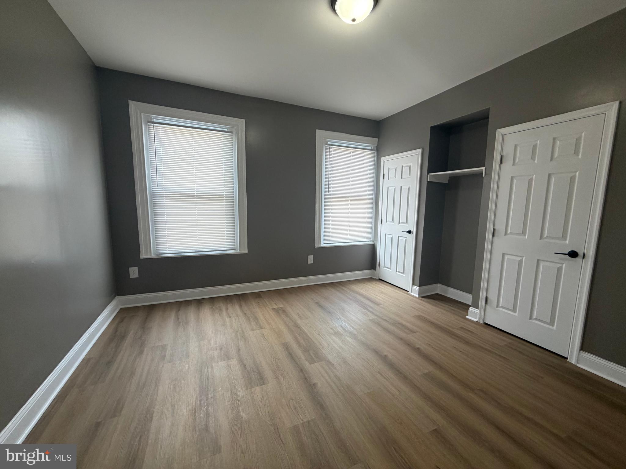 2260 North 18th Street Philadelphia, PA 19132 - Photo 13 of 13 an empty room with wooden floor and windows