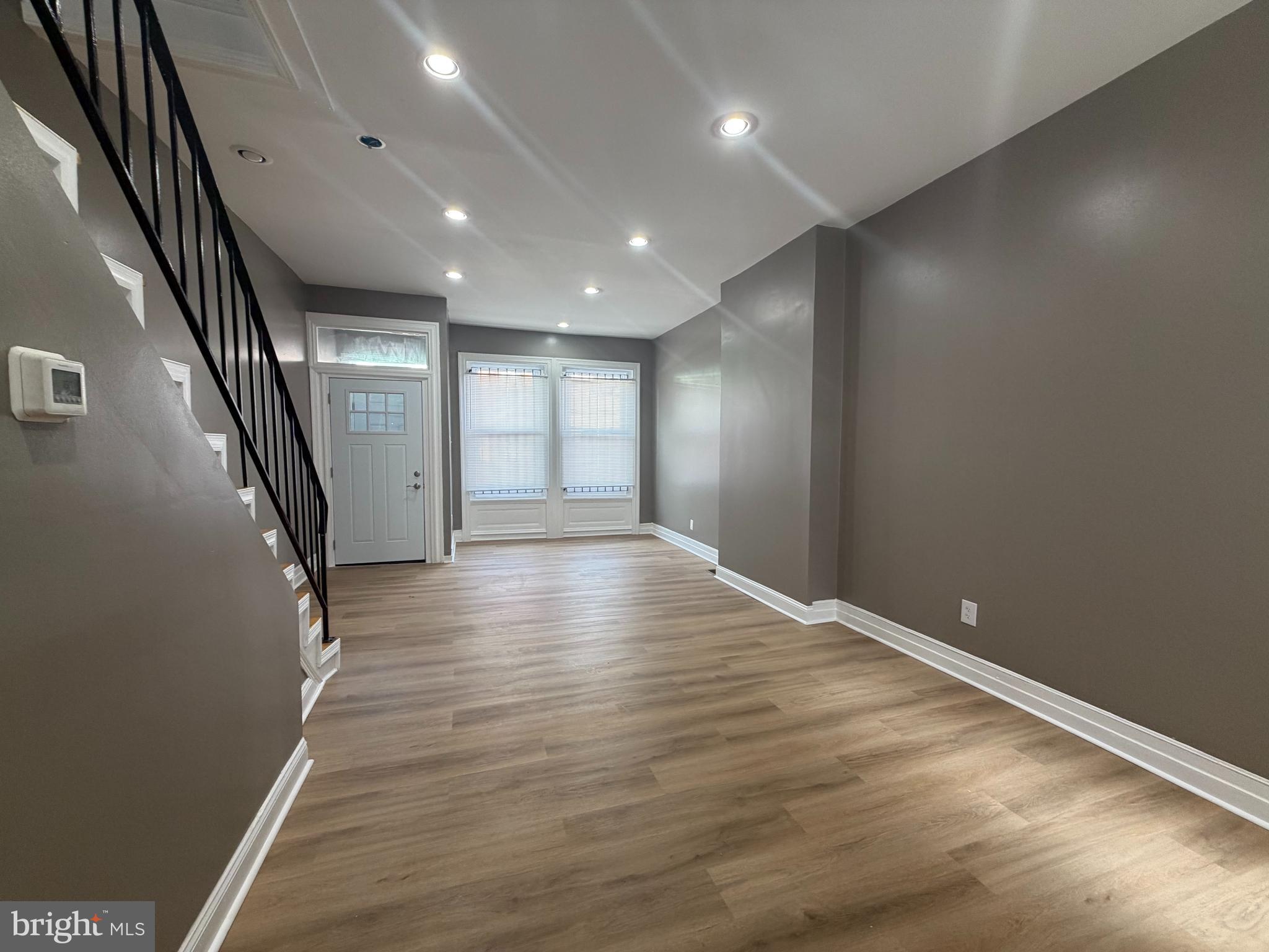 2260 North 18th Street Philadelphia, PA 19132 - Photo 3 of 13 an empty room with wooden floor and windows